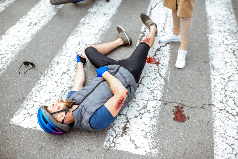 Road accident with injured cyclist and car