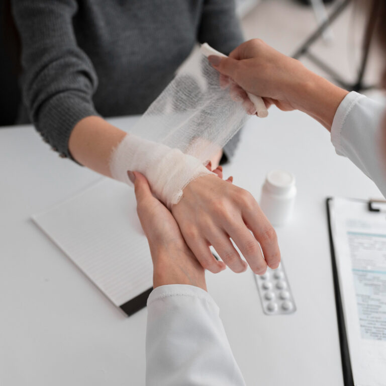 Doctor wrapping a bandage on patient hand